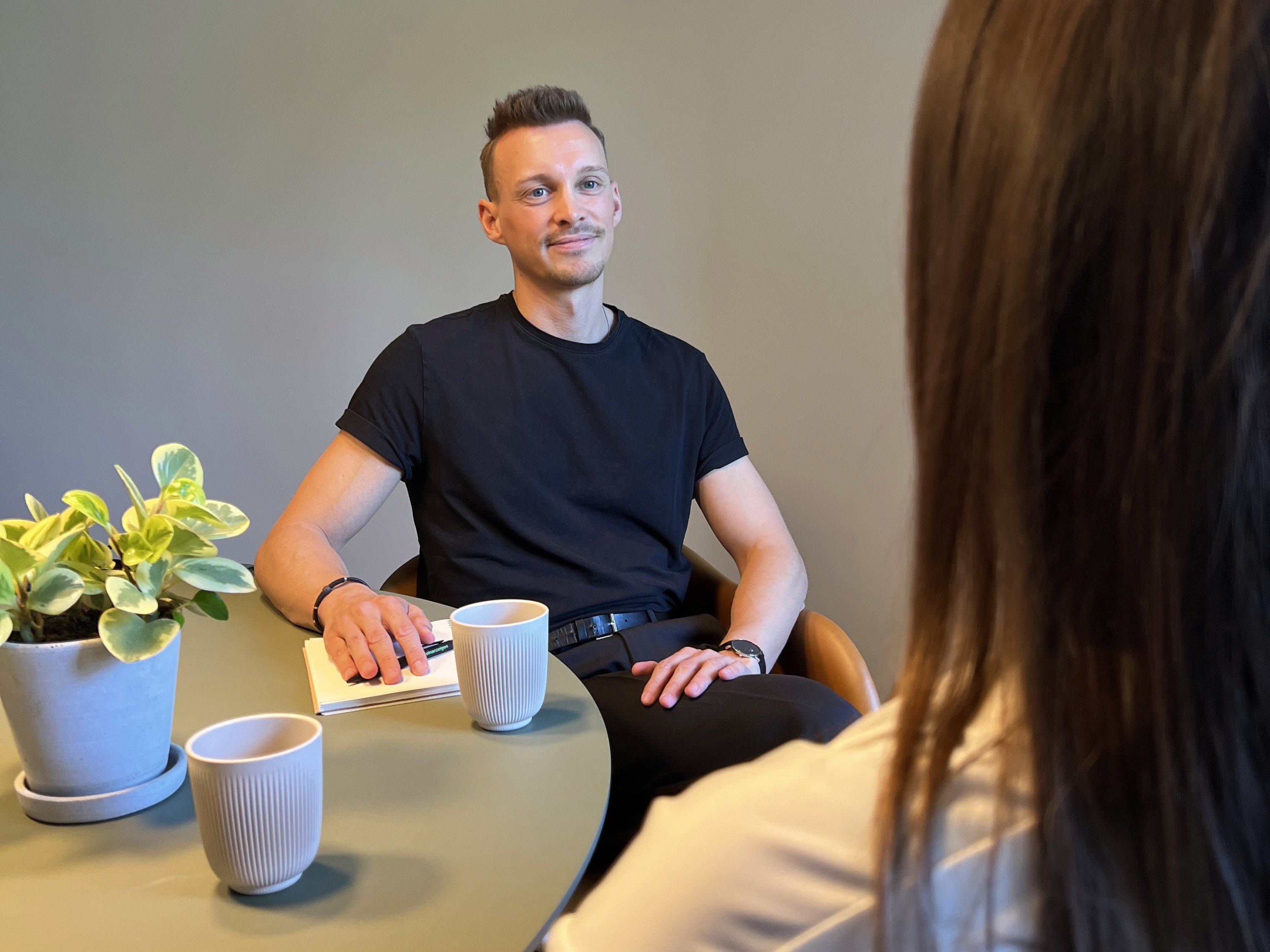 Frederick Marczyk im Gespräch mit einer Klientin am Tisch